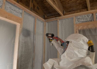 Austin Company | worker in protective gear installing spray foam insulation