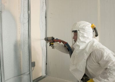 Austin Company | worker in protective gear installing spray foam insulation