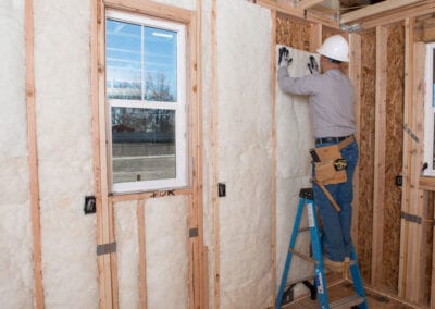 Austin Company | worker installing fiberglass in walls of home